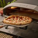 Ooni 14" Signature Perforated Pizza Peel with pizza going into oven