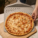 Ooni 14" Signature Perforated Pizza Peel with pizza placing into board
