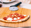 Ooni 12" Bamboo Pizza Peel with pizza and pizza cutter