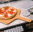 Ooni 12" Bamboo Pizza Peel with pizza and pizza cutter