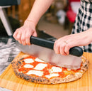Person utting pizza in Ooni 12" Bamboo Pizza Peel