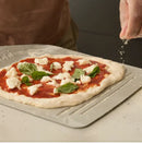 person preparing pizza using Ooni 12" Compact Pizza Peel