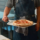 person holding Ooni 12" Compact Pizza Peel with pizza