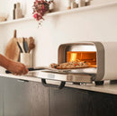 Ooni 12" Compact Pizza Peel with pizza going into oven