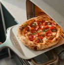 Ooni 12" Compact Pizza Peel with pizza going into oven